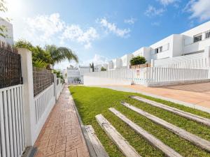 a yard with a white fence and grass at Apartamento Luna en Conil in Conil de la Frontera