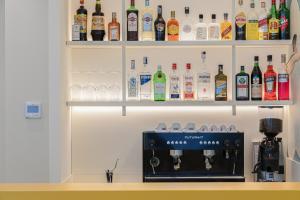 a shelf filled with alcohol bottles and glasses at Hotel Geminus B&B in Cesenatico