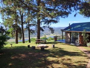 a house with a picnic table and a bench in the grass at Wild fig Cottage in Sedgefield