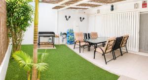 a patio with a table and chairs and a grill at Apartamento Luna en Conil in Conil de la Frontera