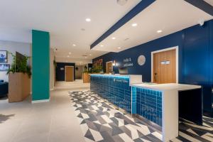 a hospital lobby with blue walls and a counter at Travelodge Bilbao Sestao in Sestao +88 photos
