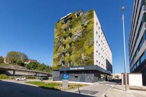 a tall building with a green wall at Travelodge Bilbao Sestao in Sestao