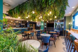 a restaurant with tables and chairs and plants at Travelodge Bilbao Sestao in Sestao