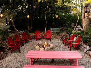 a group of red chairs around a fire pit at The Garden House in Saco