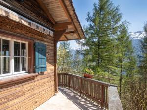 a log cabin balcony with a view of the mountains at Chalet with fireplace and sauna in Meiringen