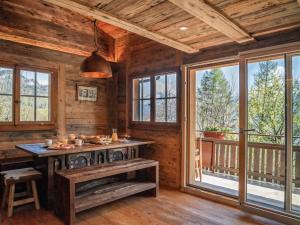 a dining room with a table and windows in a cabin at Chalet with fireplace and sauna in Meiringen