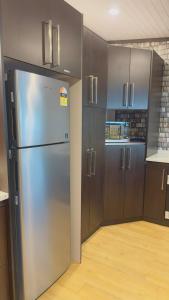 a kitchen with a stainless steel refrigerator and wooden cabinets at Simla 16 in Lautoka