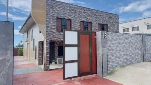 a brick house with a red door and a fence at Simla 16 in Lautoka