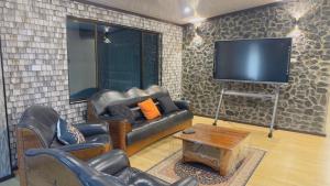 a living room with leather furniture and a flat screen tv at Simla 16 in Lautoka