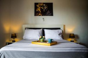 a bed with a tray with flowers on it at L'appartement Bleu d'Assinie in Assinie