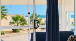 a view of the beach from a room with a window at Sunset Sails 2 Apartment in Langstrand