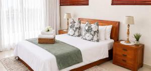 a bedroom with a bed with white sheets and pillows at Sunset Sails 2 Apartment in Langstrand