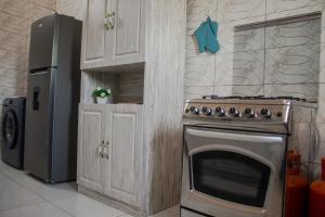 a kitchen with a stove and a refrigerator at L'appartement Bleu d'Assinie in Assinie +6 photos