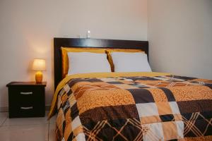 a bedroom with a bed and a lamp on a night stand at L'appartement Bleu d'Assinie in Assinie