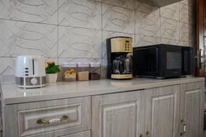a kitchen counter with a microwave and a coffee maker at L'appartement Bleu d'Assinie in Assinie