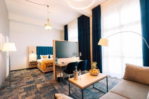 a hotel room with a bed and a living room at H24 Parkhotel Thale in Thale