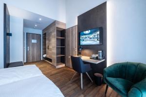 a hotel room with a bed and a desk and a chair at Hotel Krone - Aktiv & Erholt in Churwalden