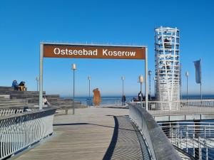 a wooden boardwalk with a sign that readsostpectedboard kesserkatown at Ferienwohnung 15 in Koserow in Koserow