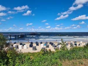 a beach with chairs and a pier and the ocean at Ferienwohnung 15 in Koserow in Koserow