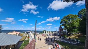 a group of people walking on a sidewalk near the water at Ferienwohnung 15 in Koserow in Koserow