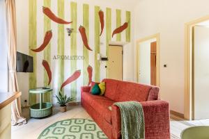 a living room with a red chair and hot dogs on the wall at Aromatico design 2 camere da letto / centralissimo in Diano Marina