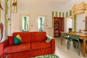 a living room with a red couch and a table at Aromatico design 2 camere da letto / centralissimo in Diano Marina