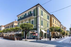a green building on a city street with trees at Aromatico design 2 camere da letto / centralissimo in Diano Marina