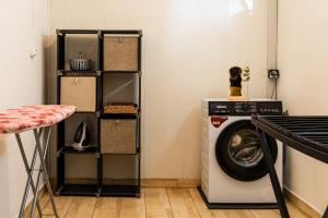 a laundry room with a washing machine and a shelf at Villa BELLEVUE in Bras-Panon