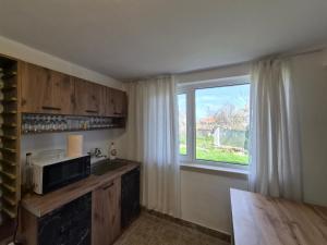 a kitchen with a microwave and a window at Blue Summer in Obzor