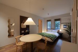 a bedroom with a bed and a table and chairs at The Apartment Hotel Shibuya 3 in Tokyo