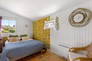 a bedroom with a bed and a chair and a window at Le Grand Pré du Clos Champêtre in Longué