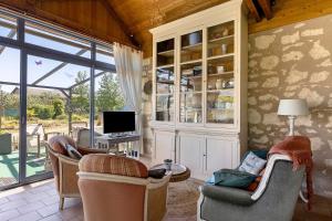 a living room with chairs and a desk with a computer at Le Grand Pré du Clos Champêtre in Longué