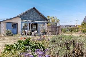 a cottage with a garden with purple flowers at Le Grand Pré du Clos Champêtre in Longué