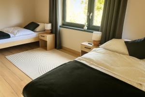 a bedroom with two beds and a window at Stodoły ForRest in Czarna