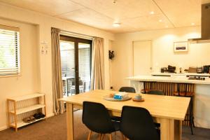 a room with a table and chairs and a kitchen at Serene Star in Lake Tekapo