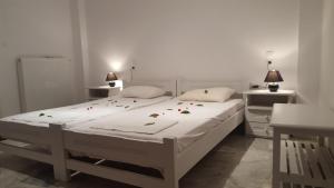 a bedroom with a white bed with flowers on it at Varmy in Ierapetra