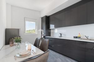 a kitchen with a table and chairs and a sink at Elegant Seaview 1bd in Dobre Vode in Dobra Voda