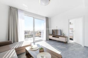 a living room with a couch and a large window at Elegant Seaview 1bd in Dobre Vode in Dobra Voda