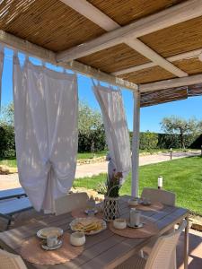 a picnic table under a pergola with food on it at Casa Adriano-Dimora per vacanze in Ripa Teatina