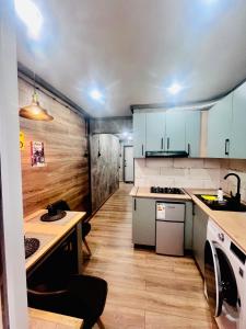 a kitchen with blue cabinets and a wooden floor at Лофт в самом сердце Караганды in Karagandy