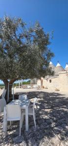 a white table and chairs under a tree at Casa Relax Isabelle in Alberobello