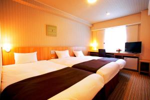 Tempat tidur dalam kamar di Nest Hotel Sapporo Ekimae