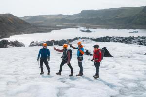 a group of people standing on top of a glacier at Adventure Stay in Vík +14 photos