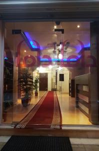 a glass window with a red carpet in a building at Kasr Dama Furnished Apartments in Ḑubā
