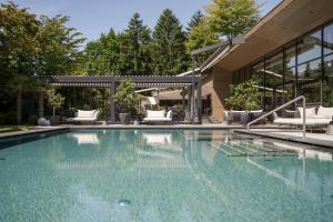 a swimming pool in front of a house at Feldhof DolceVita Resort in Naturno