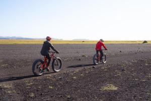 two people riding bikes on a dirt road at Adventure Stay in Vík