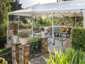 a white gazebo in a garden with plants at Villa Tommaso Maruggi, Sicilia, con Jacuzzi e piscina privata in Alcamo +55 photos