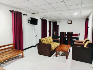 a living room with two chairs and a tv at Malwathu oya resort in Anuradhapura