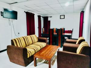 a living room with two chairs and a couch and a table at Malwathu oya resort in Anuradhapura