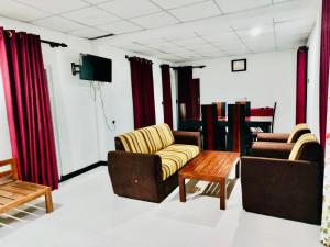 a living room with two couches and a tv at Malwathu oya resort in Anuradhapura +1 photo